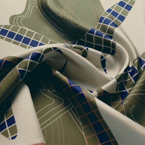 The Quatrefoil silk carré, draped — the sheen of the silk twill