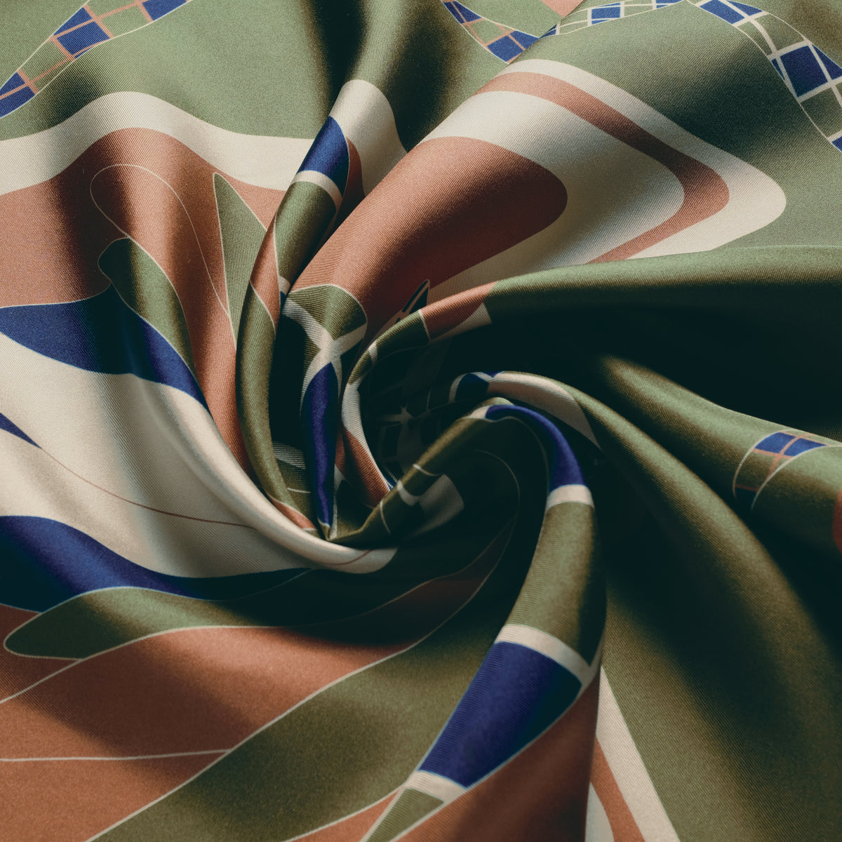 The Graft silk carré, draped — the sheen of the silk twill